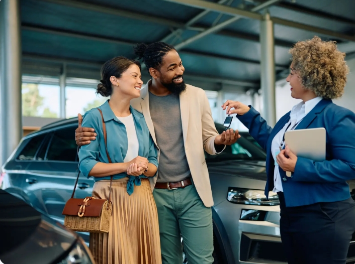 young couple taking car keys from salesperson