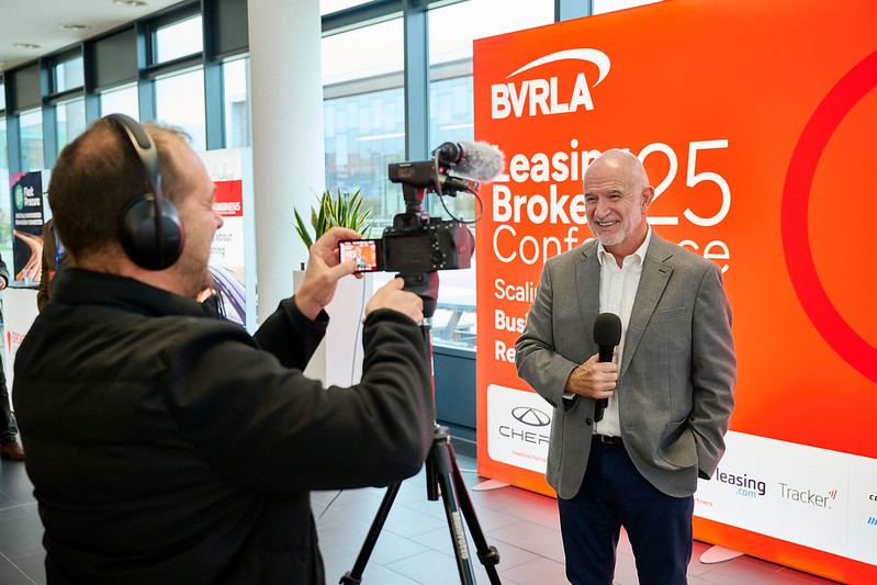 The BVRLA Leasing Broker committee Chair being filmed in front of an orange backdrop