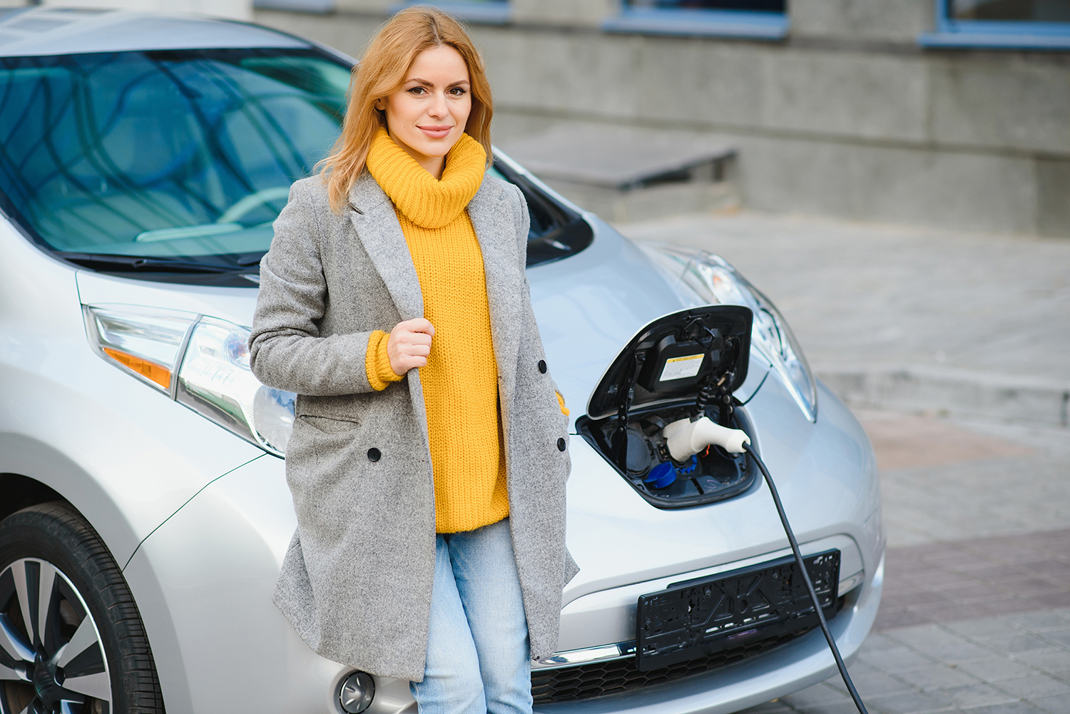 EV charging lady with yellow jumper
